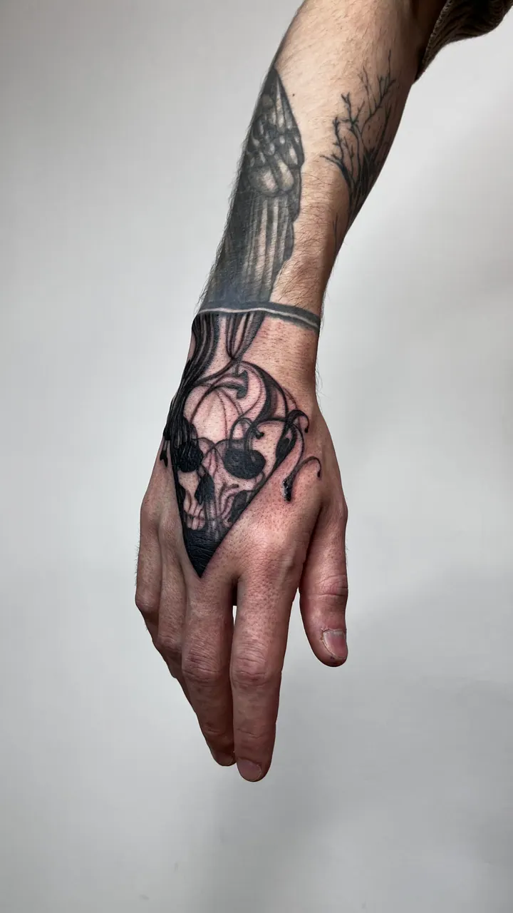 Skull tattoo with flowing lines on the hand