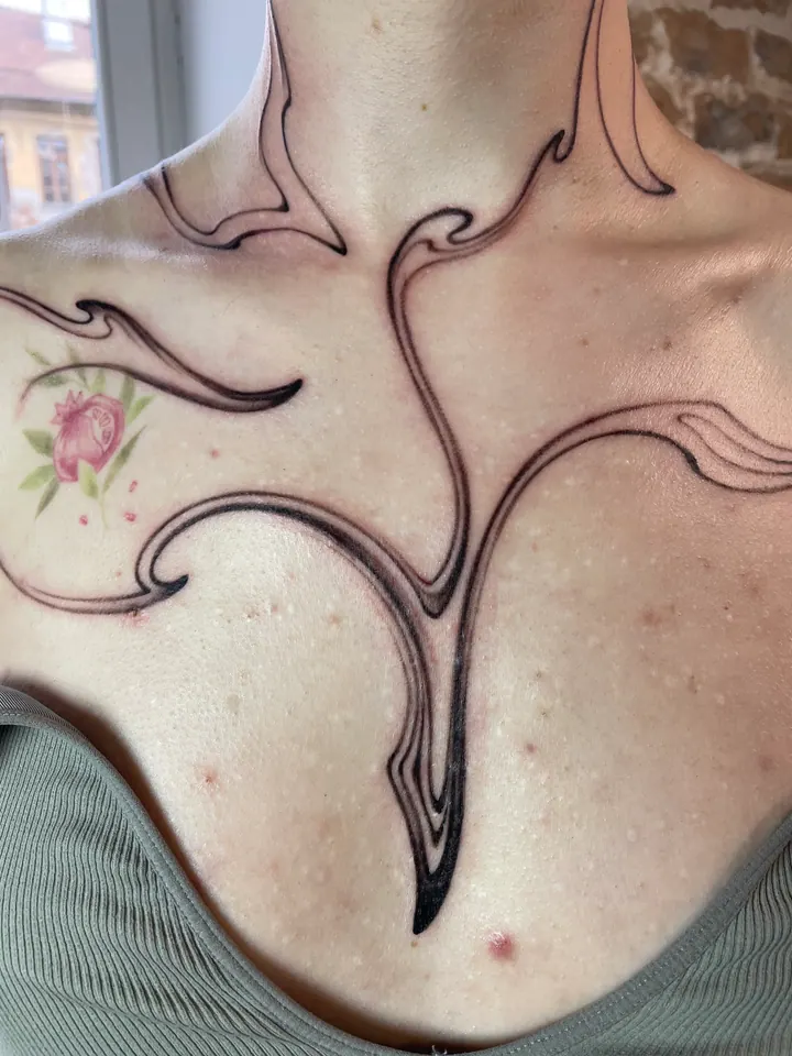 Abstract linework tattoo across the neck, shoulders and chest