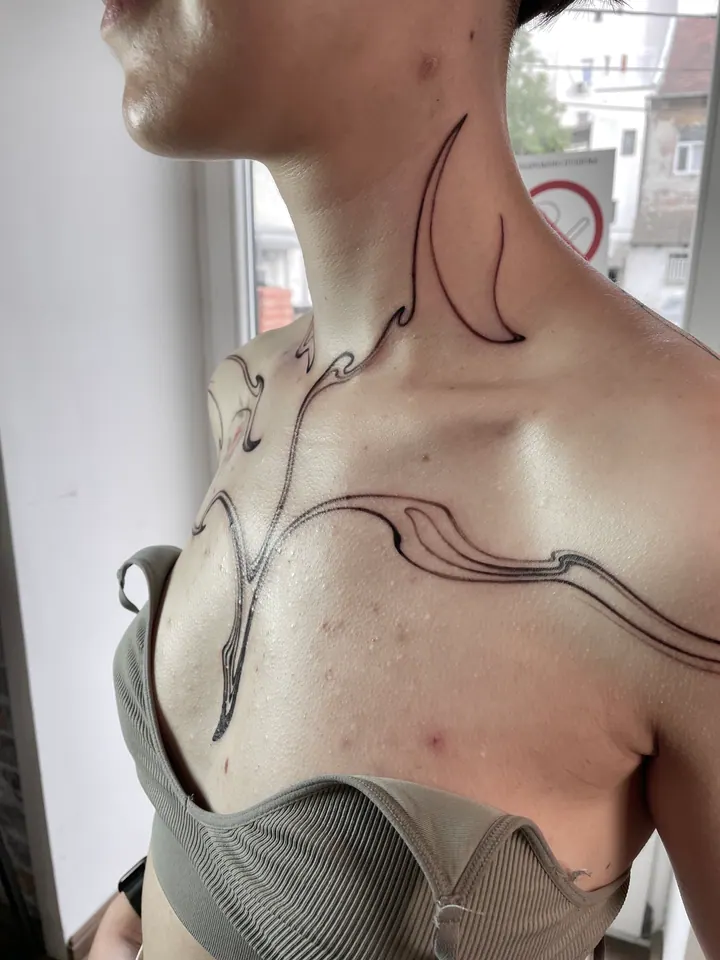 Abstract linework tattoo across the neck, shoulders and chest
