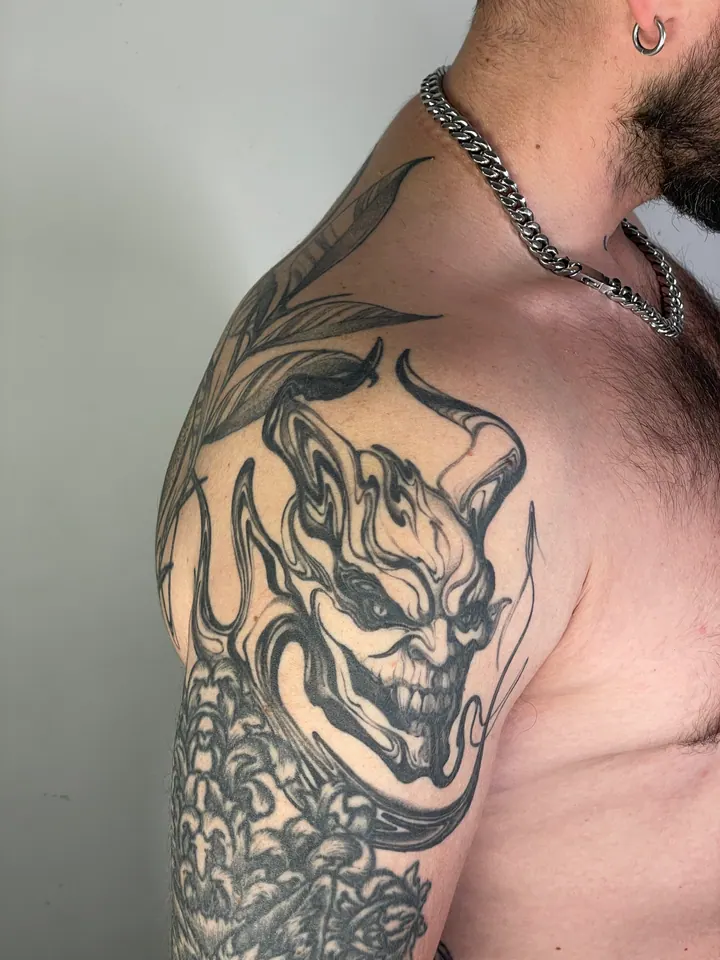 Abstract black body painting around an existing demon tattoo