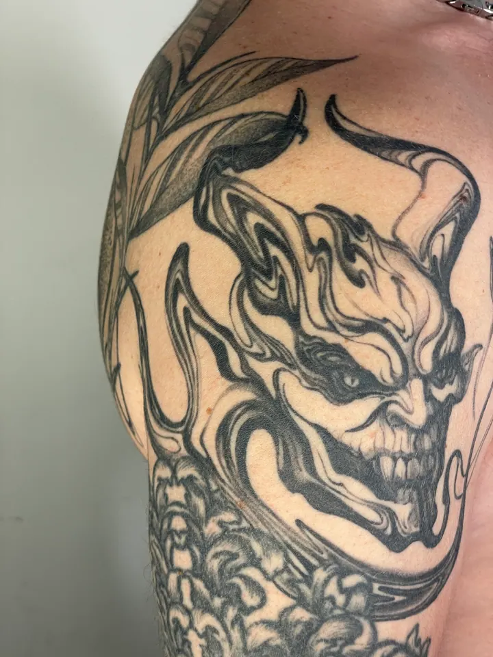 Abstract black body painting around an existing demon tattoo