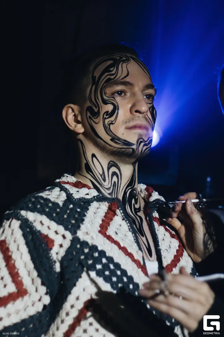 Artist painting a model’s face and neck at a live event