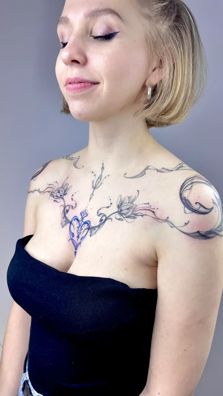 Floral chest tattoo with a blue heart design stencil