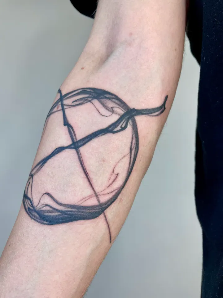 Circular abstract tattoo near the elbow