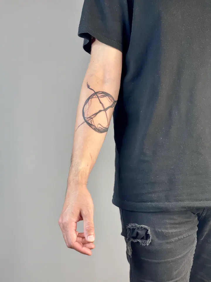 Circular abstract tattoo near the elbow