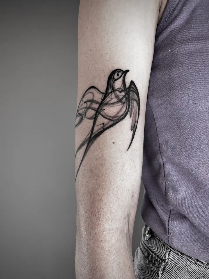 Bird tattoo with flowing abstract lines on the arm