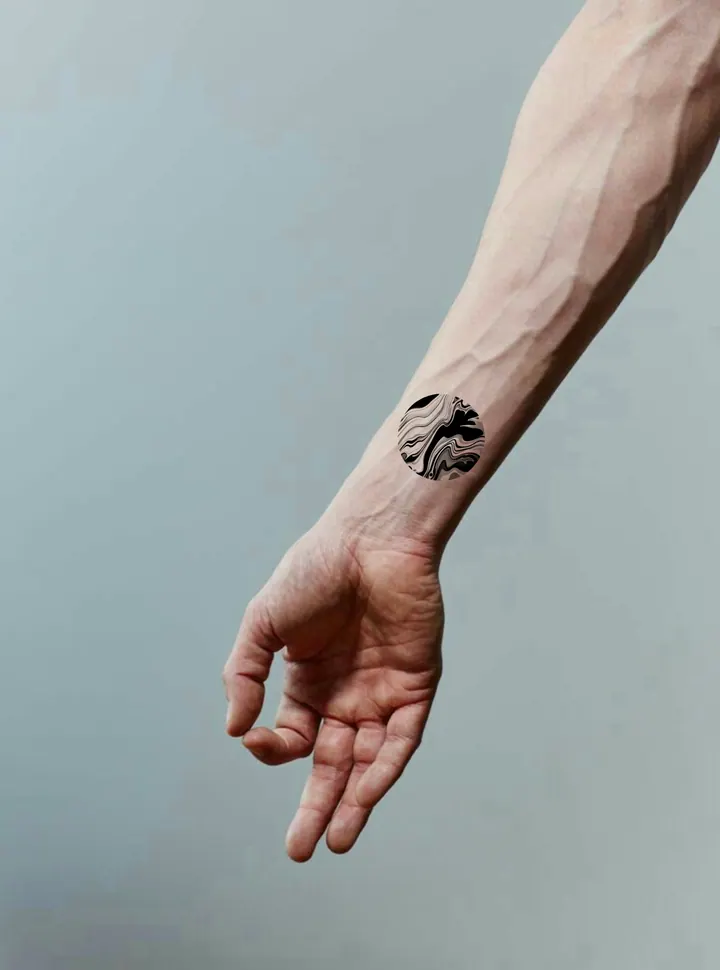 Circular abstract tattoo design shown on the wrist