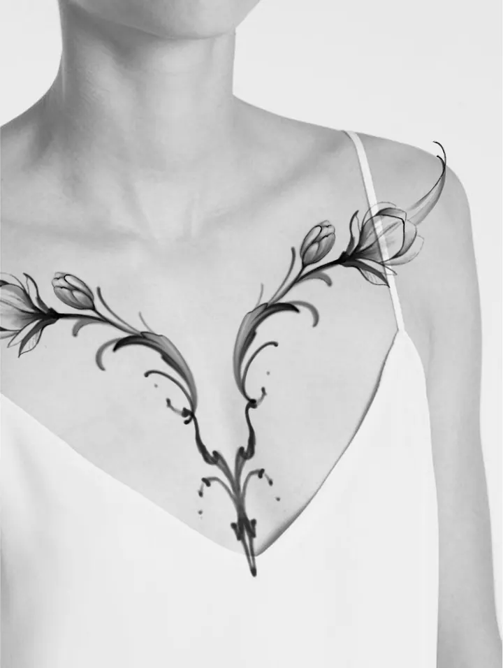 Symmetrical floral tattoo design shown on the chest